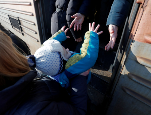 Pengungsi menaiki kereta di stasiun sebelum meninggalkan kota Makiivka (Makeyevka)